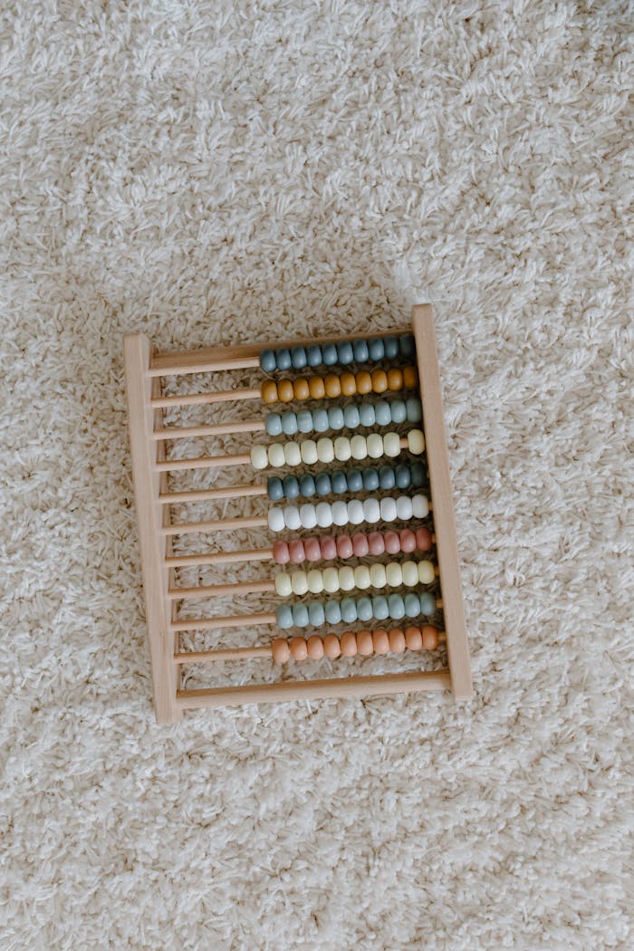 Aesthetic close-up of a colorful wooden abacus on a beige carpet, perfect for educational themes.