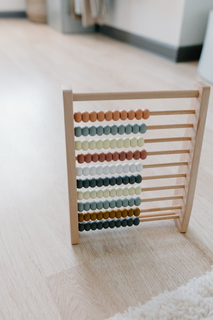 A colorful wooden abacus sitting on a wooden floor, ideal for learning and education themes.