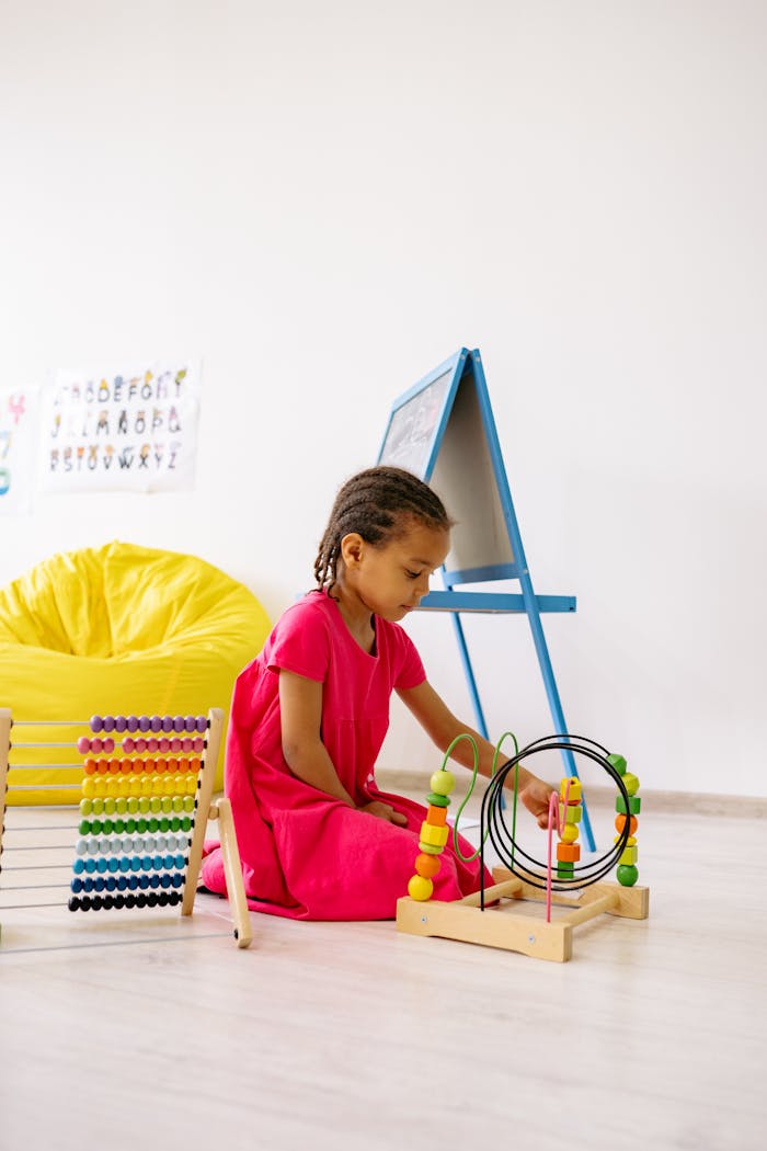 A child exploring an abacus and bead maze in a colorful classroom setting, encourages early learning.