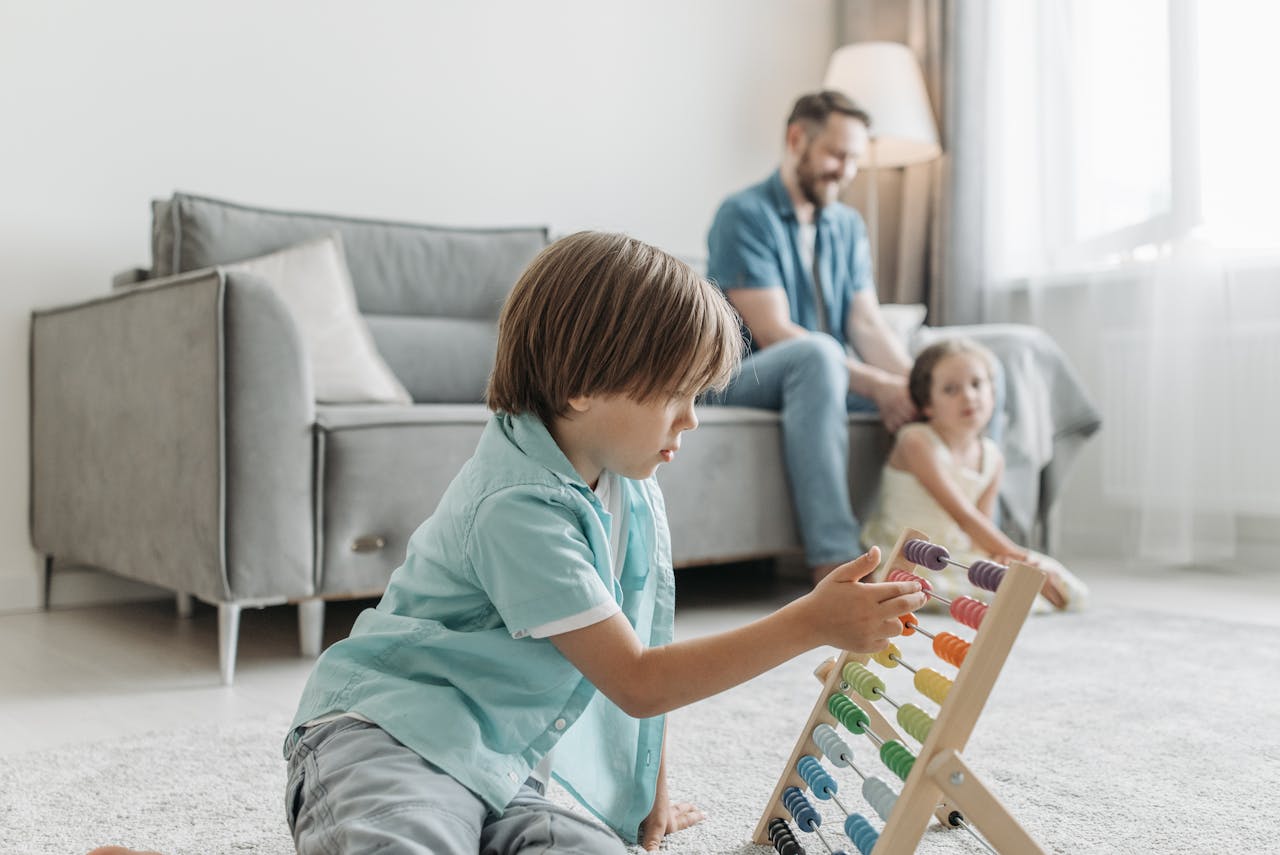 A boy playing with an abacus while family enjoys time together in a cozy living room.